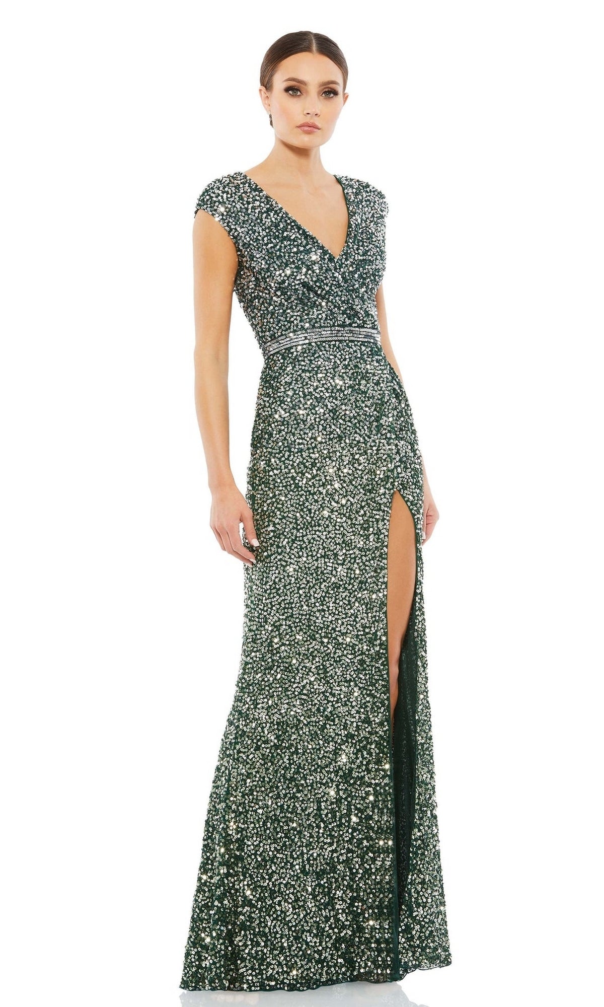 A woman wears the Mac Duggal 5489 Beaded Long Green Formal Dress, featuring short sleeves, a V-neckline, fitted waist, side high slit, and floor-length green sequins.